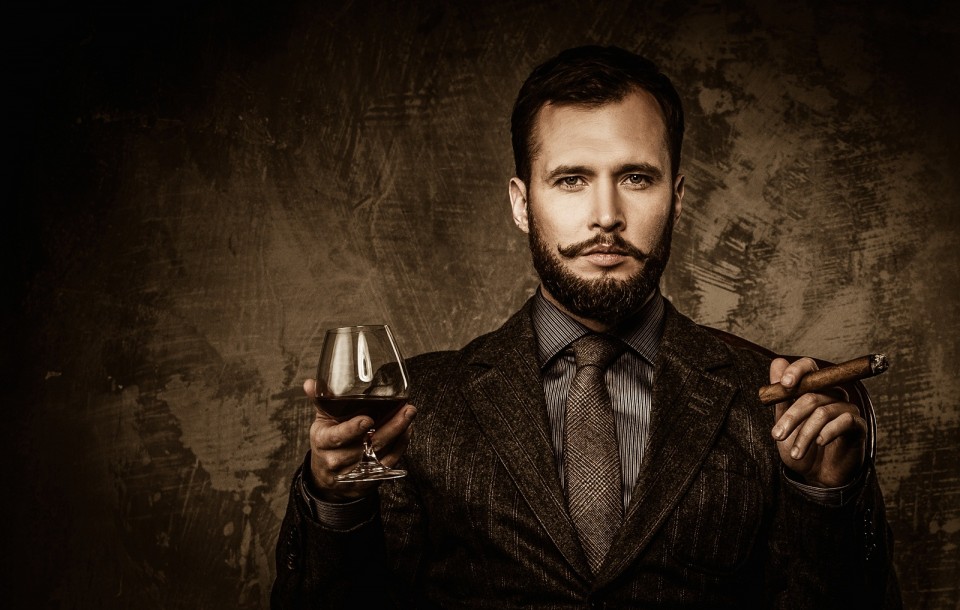Handsome well-dressed with glass of beverage and cigar